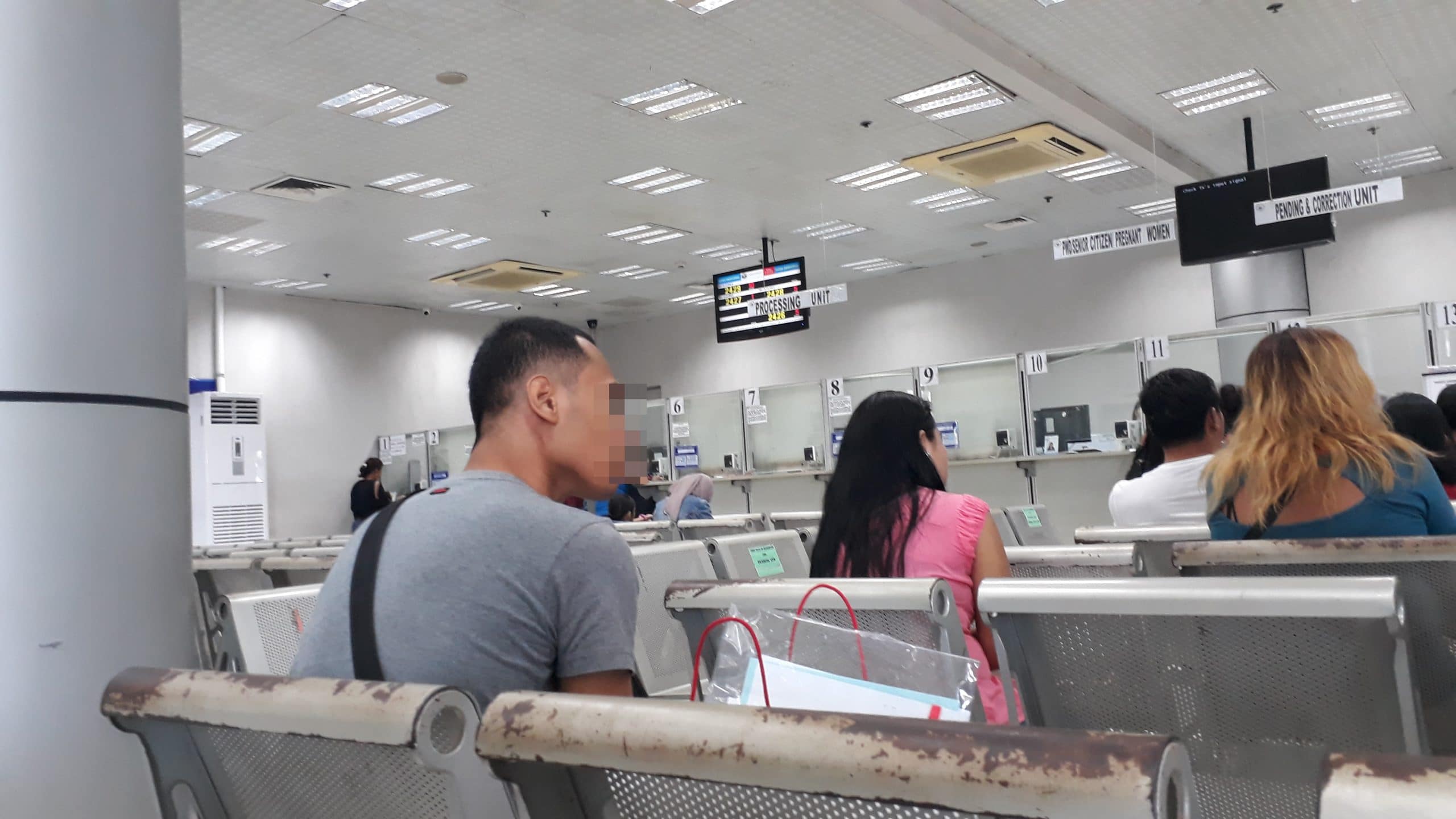 A photo of a man sat in a Department of Foreign Affairs waiting area.  Where to get Apostille in Philippines.  How to Apostille birth certificate