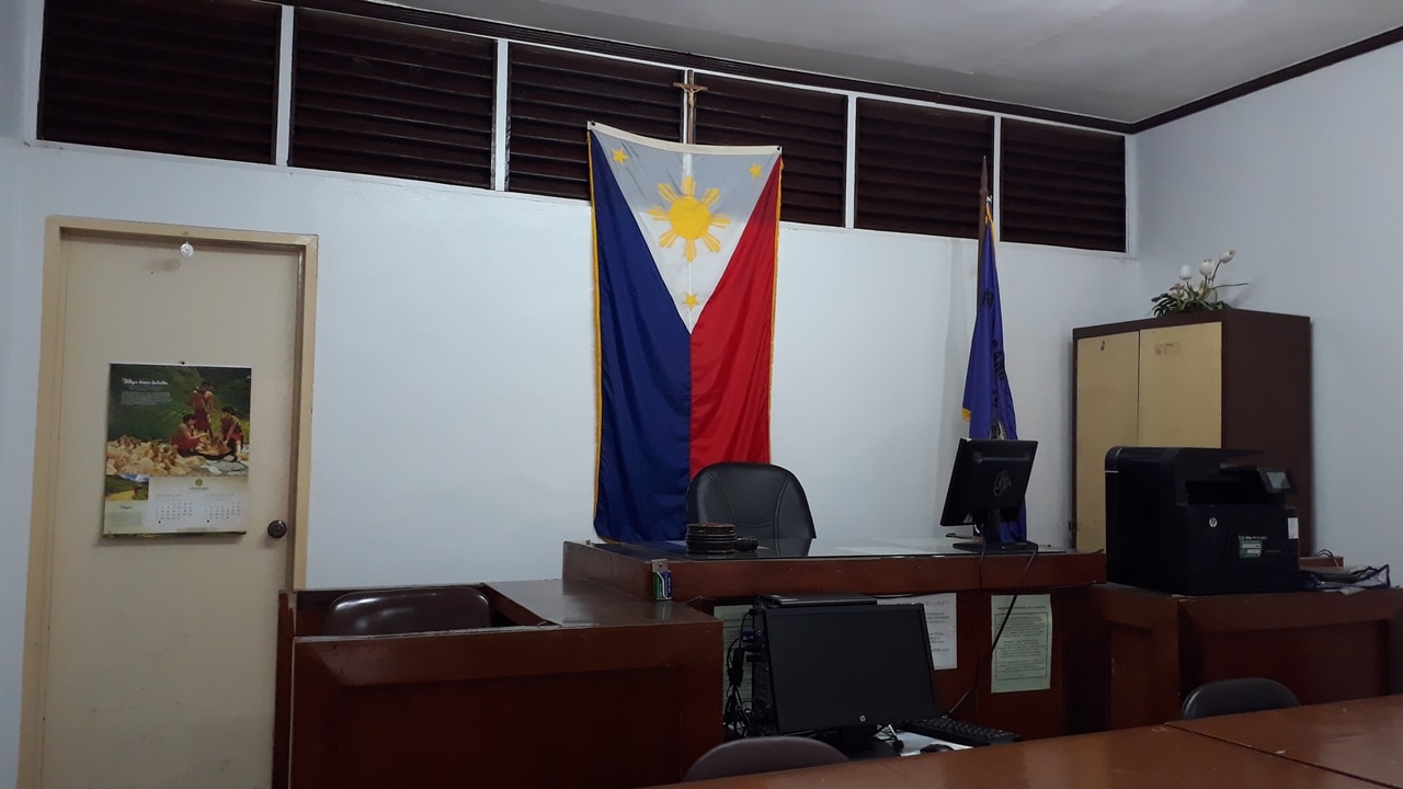 A photo of a Family Court in the Philippines where Annulment Cases will be heard. There Philippine flag is behind the Judges chair.  How to file annulment in Philippines while abroad