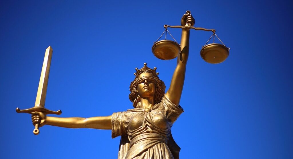 A statue of lady justice under a clear sky