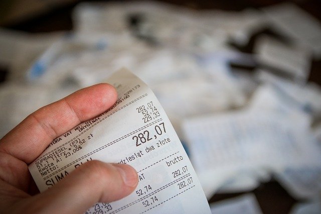 A person holding a receipt with Value Added Tax in the Philippines