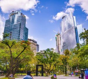 Makati towers behind the green park under a clear blue sky signifying tax free exchange in the Philippines.