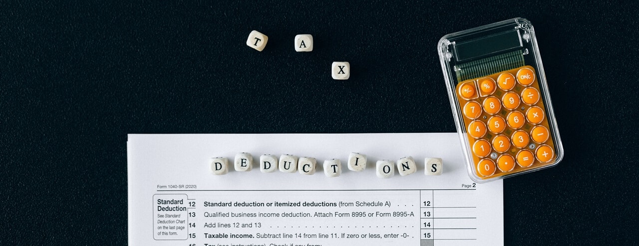 A calculator and letters forming Tax Deductions symbolizing enhanced tax deductions.