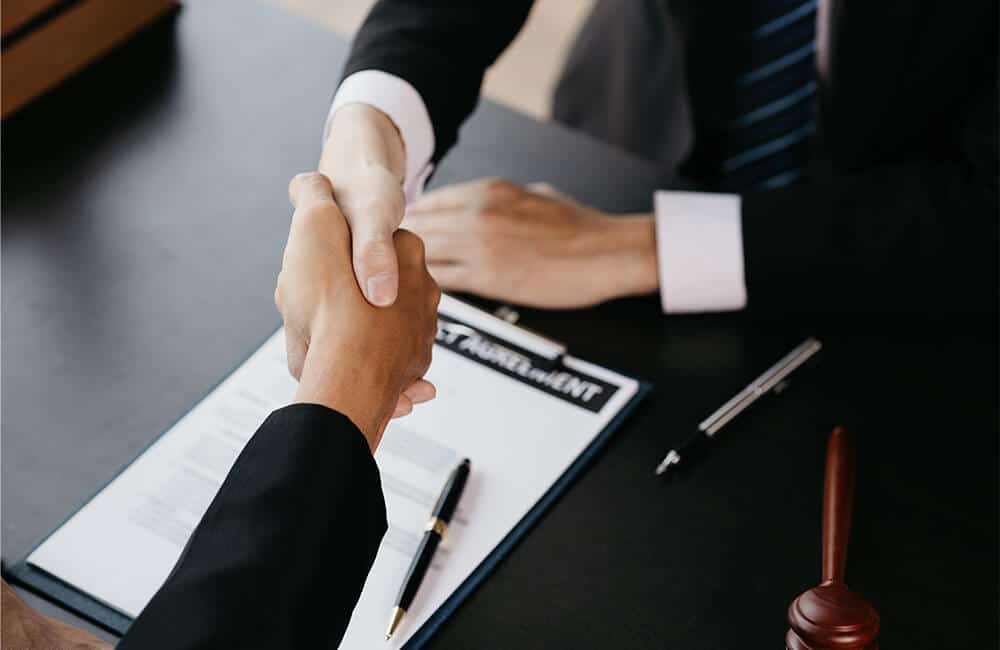 A PH Property Lawyer shaking hands with a client before the start of a Reissuance case symbolizing all the coordination needed between a client and his lawyer.