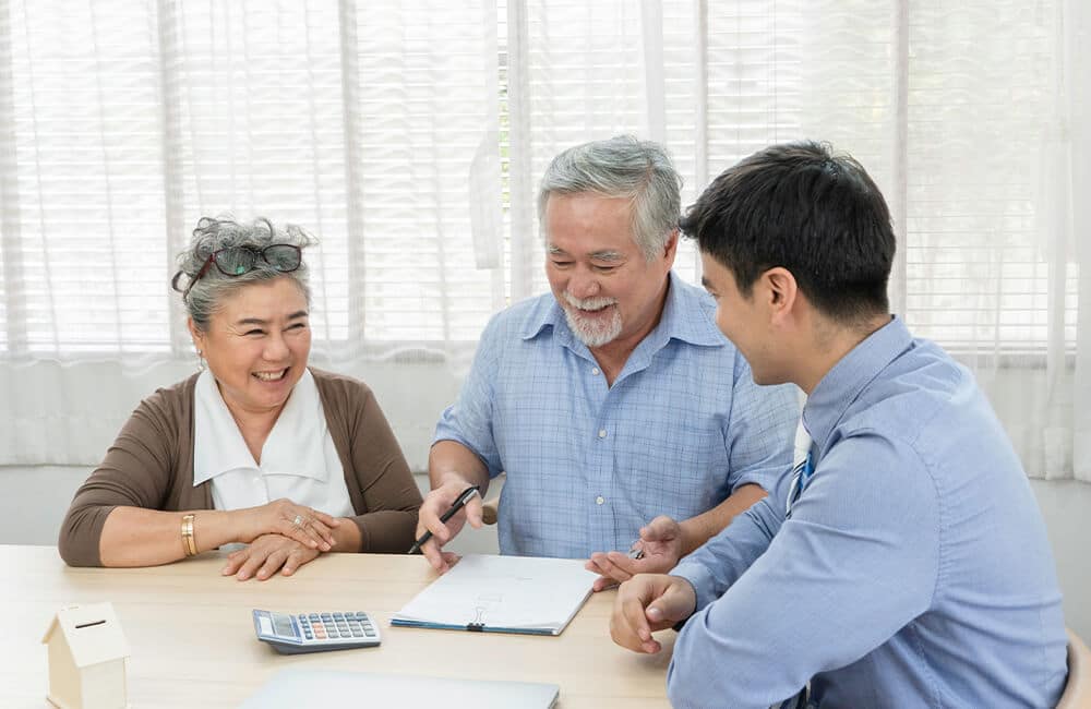 An older couple discussing their wishes in front of a lawyer as all Wills require a court case so that the Will can be used.