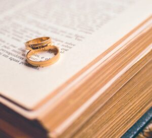 A couple's wedding ring over pages of a bible