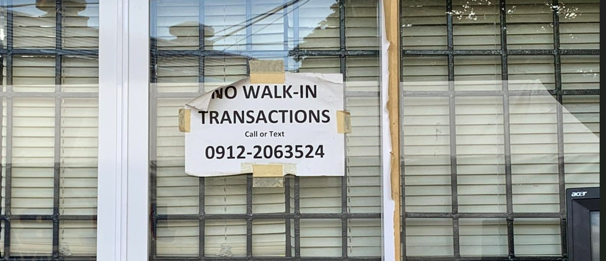 A posted sign of no walk in transactions on a government office window