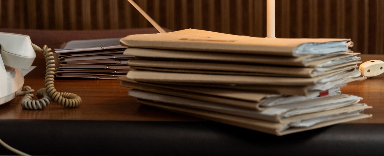 A pile of documents in folders over the table