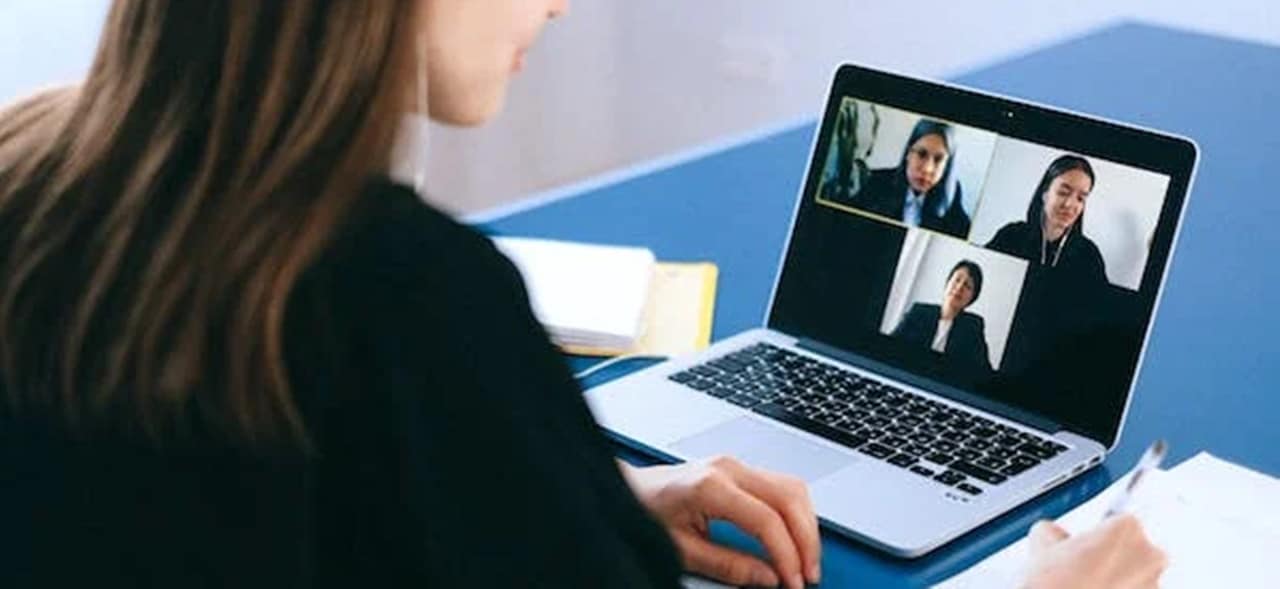 A woman having a video conference meeting with three other people