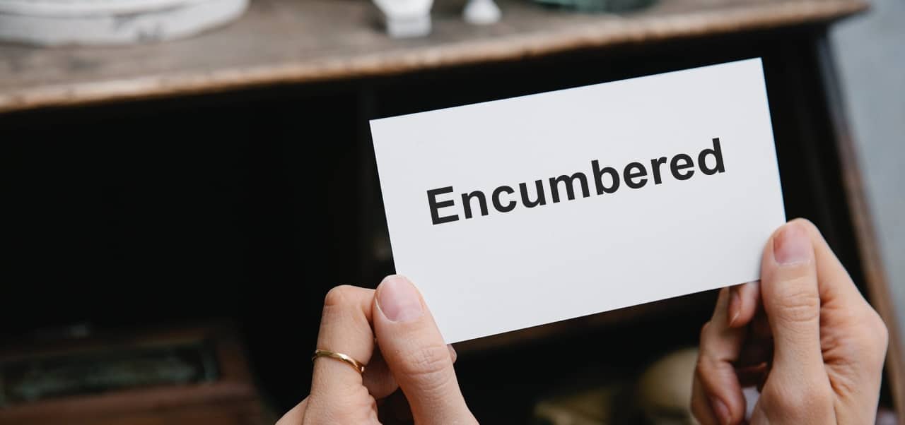 A person holding a paper with the word encumbered written on it
