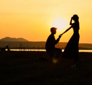 A man proposing to her girlfriend on a sunset