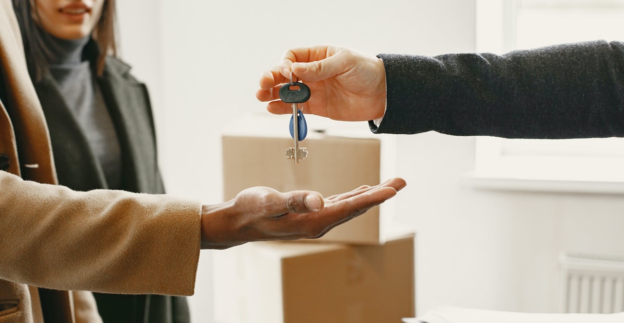 A man handing over a key to another person