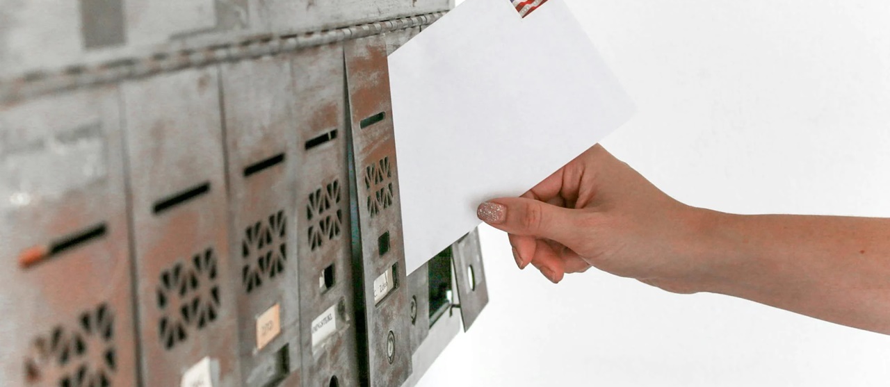 A mailman dropping a mail in the mailbox