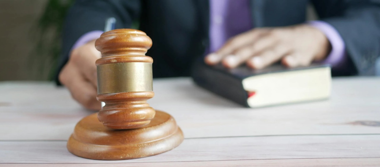 A judge holding a book and a gavel