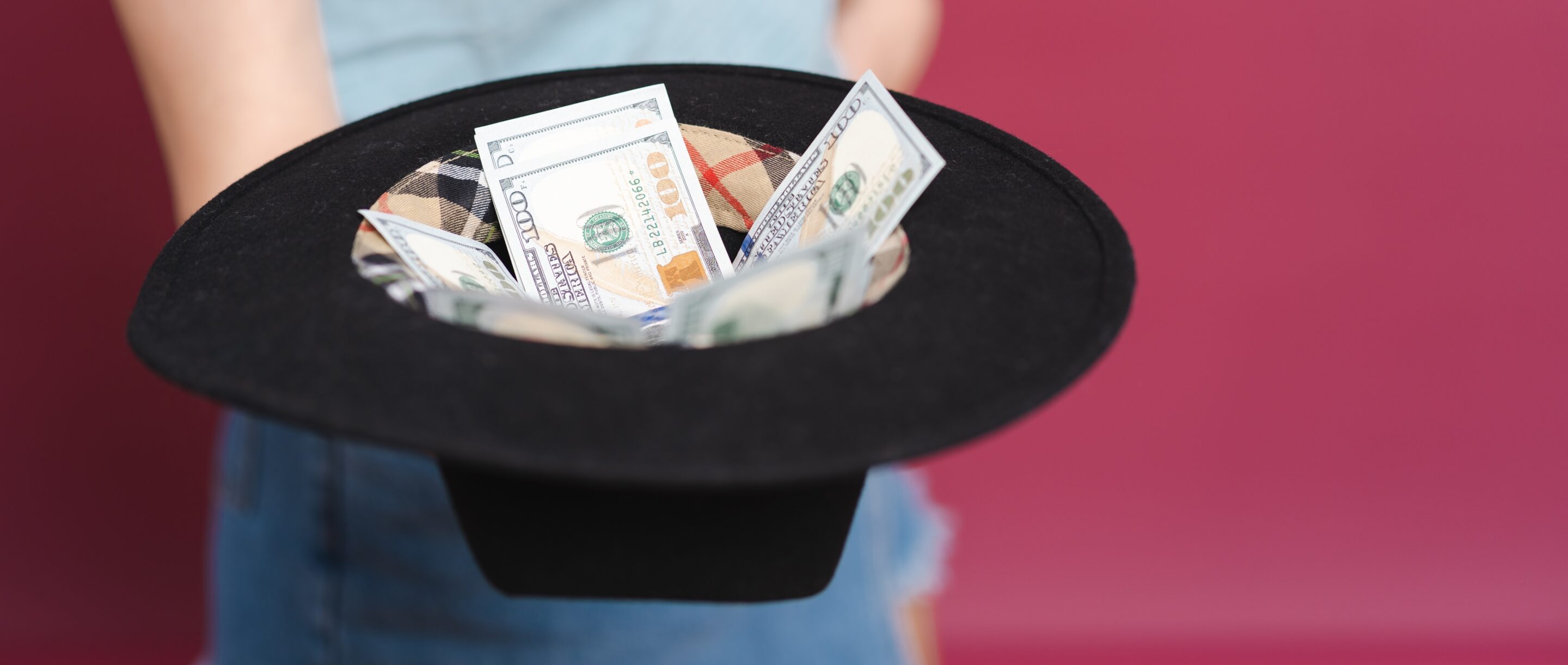 A woman holding a hat with tips signifying the costs of arbitration.