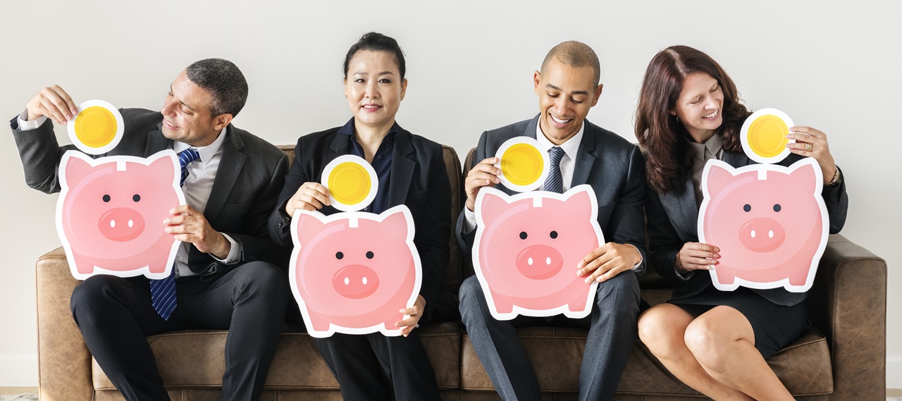 corporate people on a couch holding a piggybank cut-out