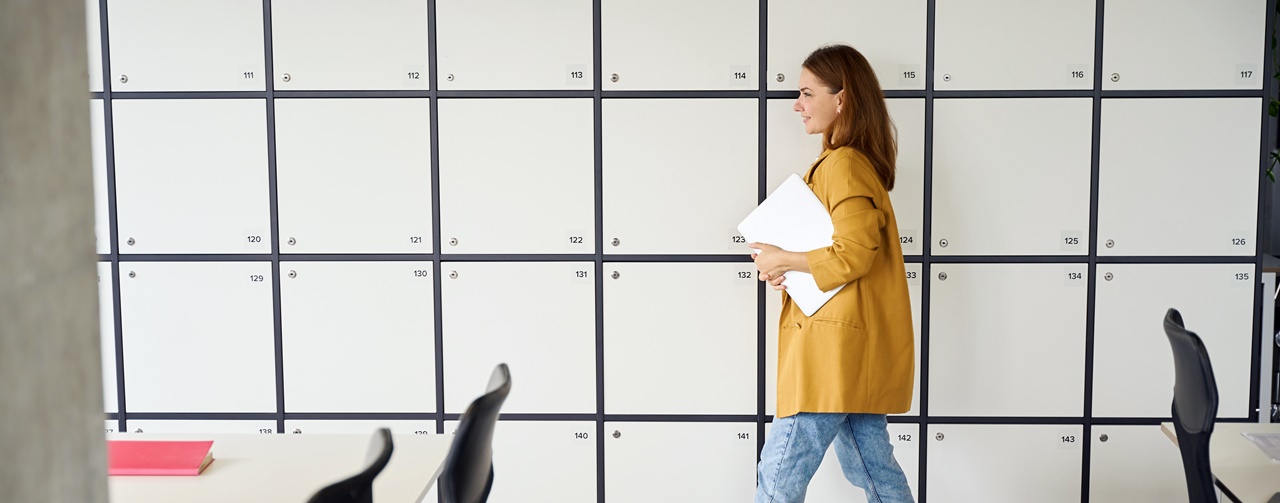 A woman walking down the hallway holding papers