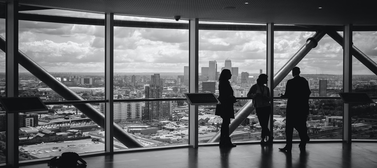 Black and white picture of three people standing on a building penthouse