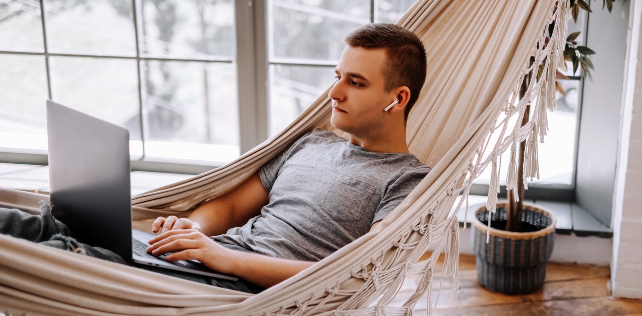 A man in a hammock with his laptop