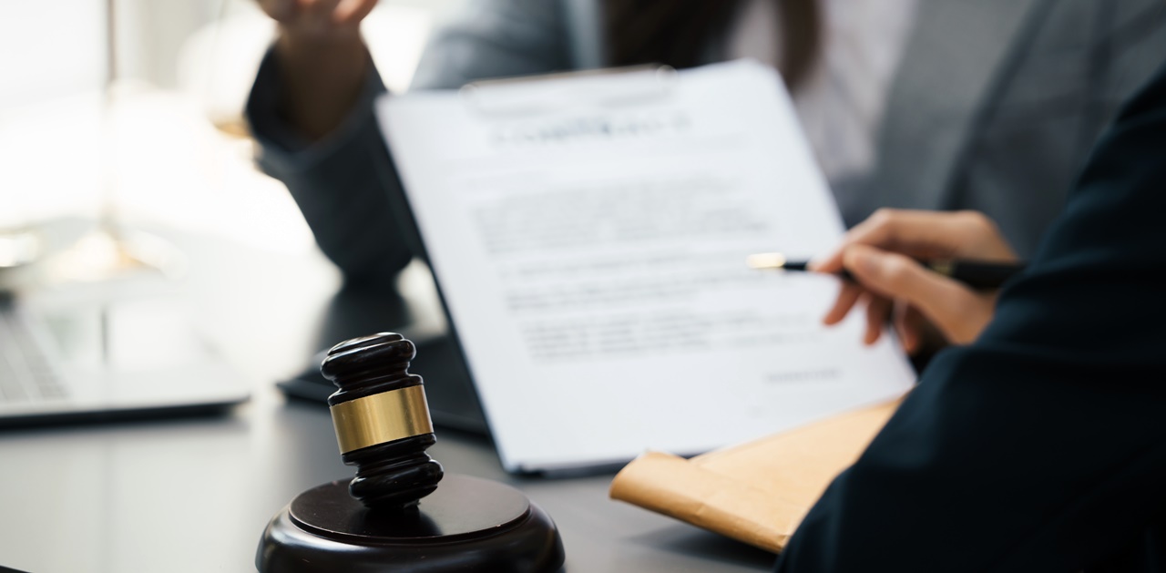 A person checking a paper work on what appears to be a judge's table