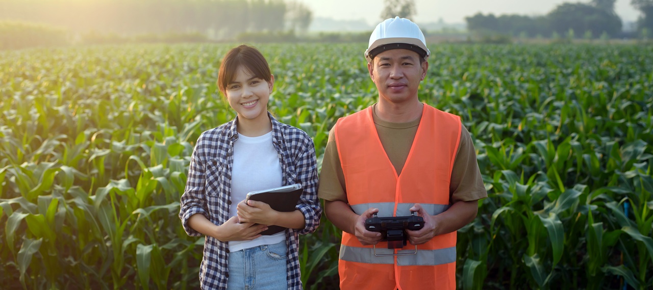 A man and a woman holding their gadgets in a farm doing research and development under Philippine Tax law