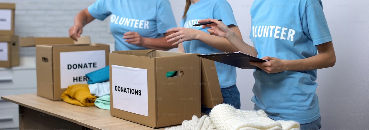 Three volunteers with boxes of donations symbolizing a foundation which is a non-profit organization in the Philippines