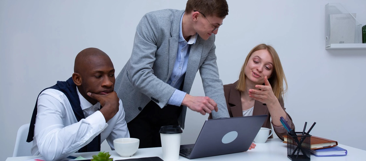 A man assisting a woman on her computer