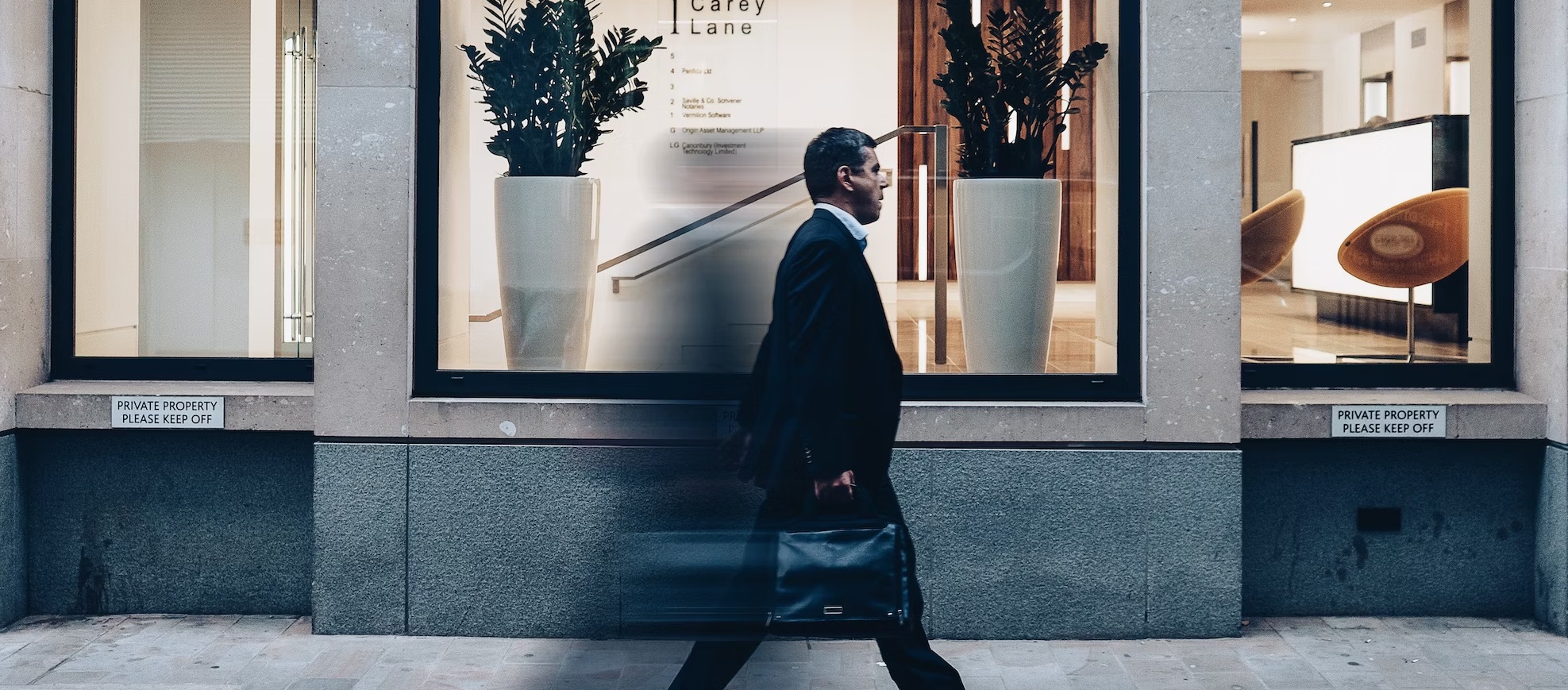 A man walking very fast on a sidewalk