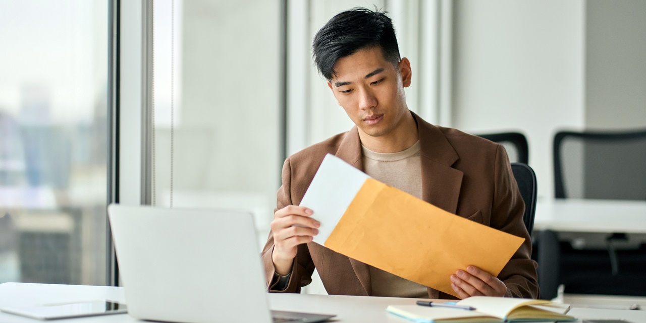 A man opening a letter envelop