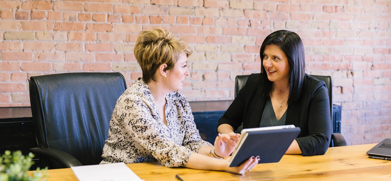 Two professional looking women talking to each other