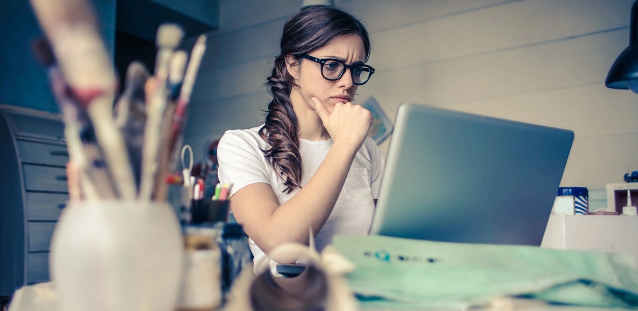 A woman on her computer thinking deeply