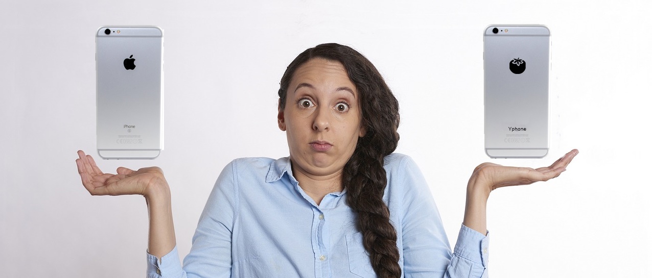 A confused woman holding two identical phones except with different logo and name