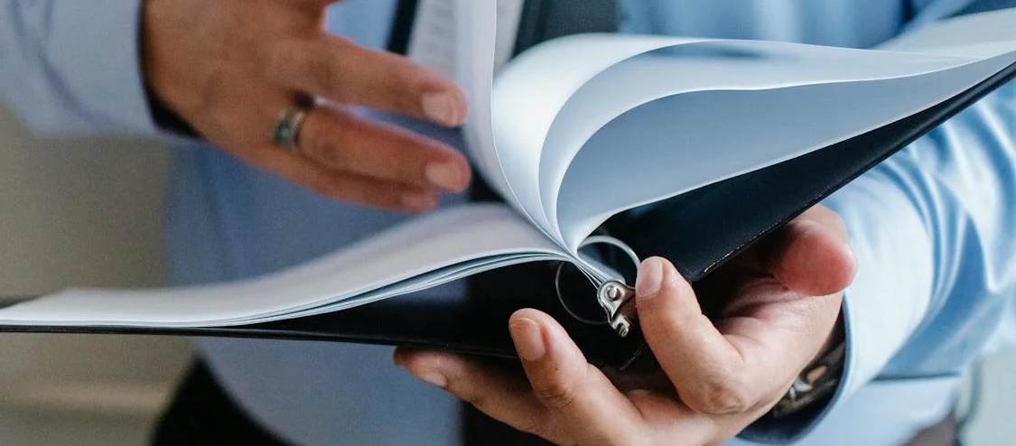 A man in formal attire flipping a book page symbolizing the diverse corporate structures in the Philippines including the limited liability company